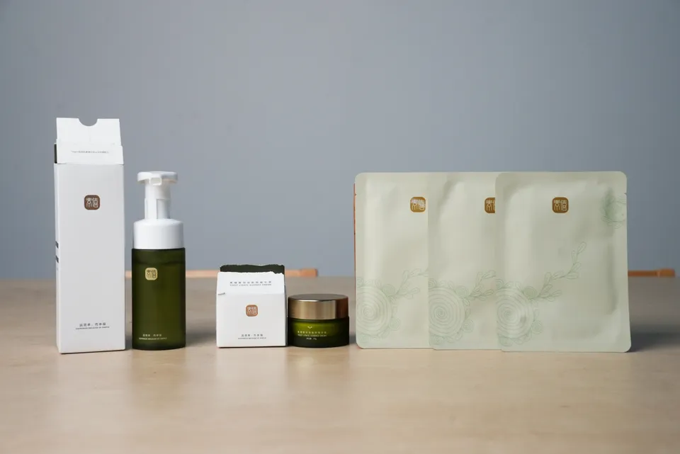 Suxi skincare products with a pump bottle, cream jar, boxes and mask sachets