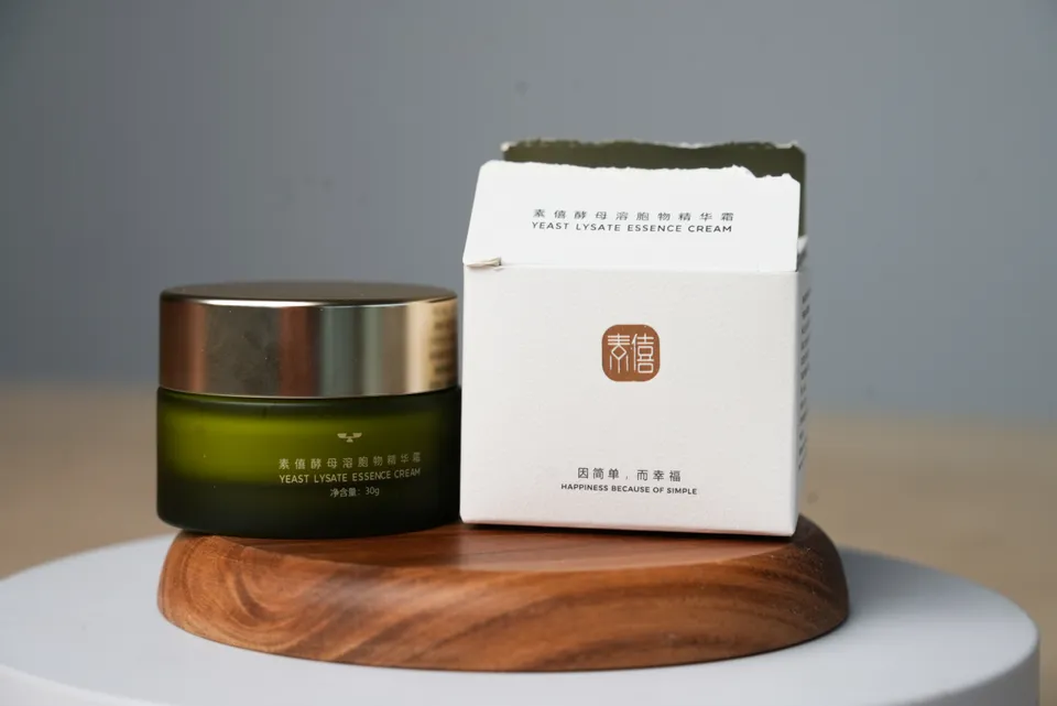 Suxi face cream jar and its box on a wooden display stand